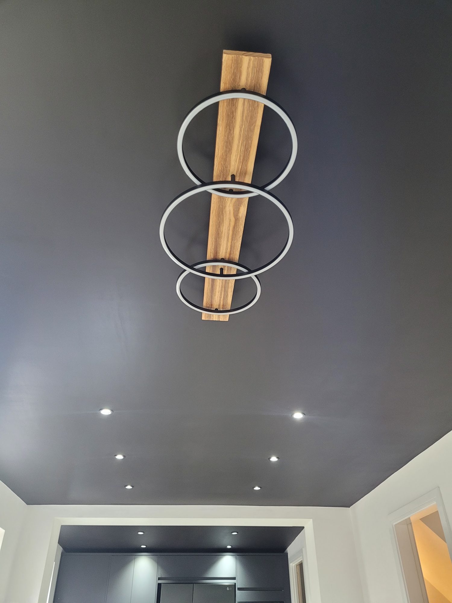 A ring pendant light on a dark ceiling above a grey kitchen