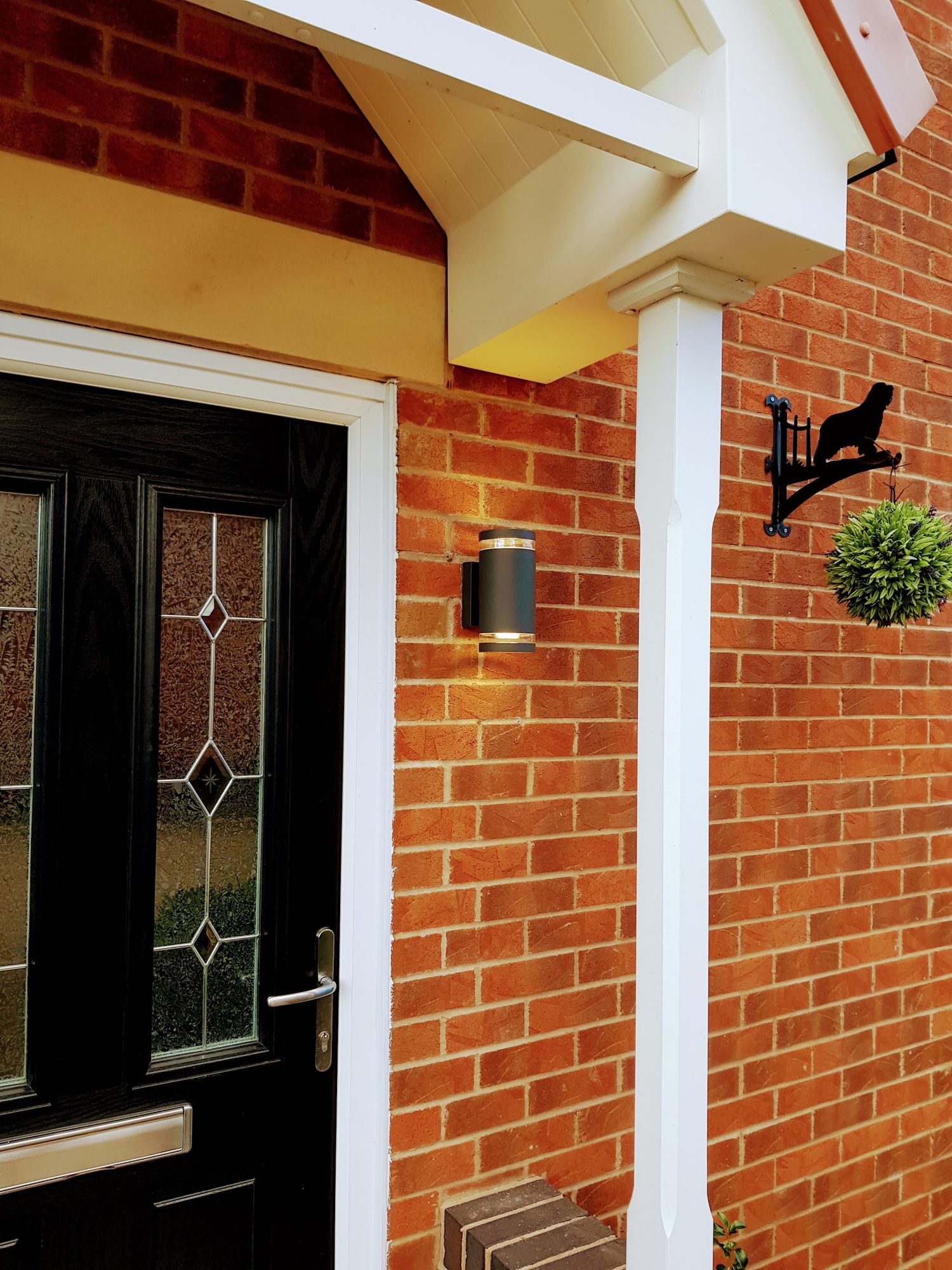 A front door with a neat porch light beside it