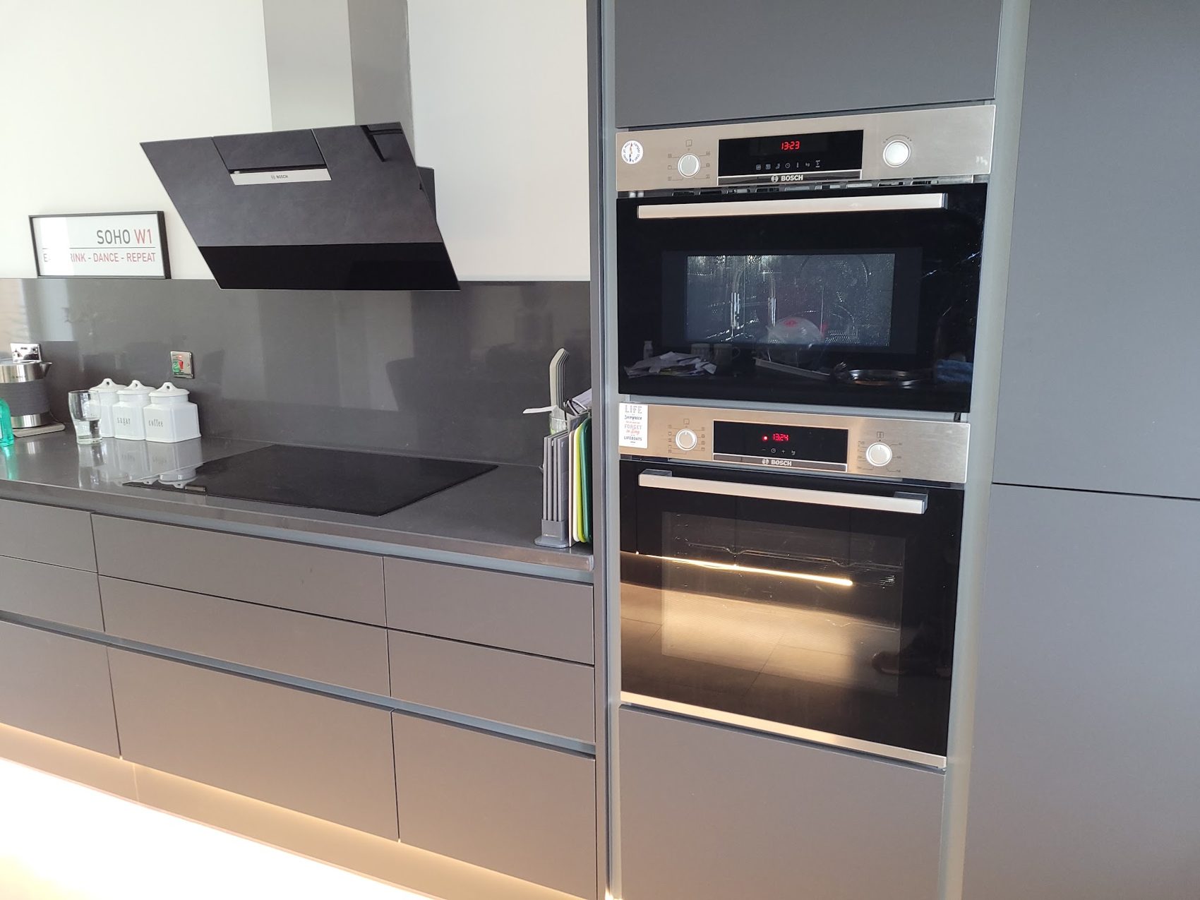 A kitchen with built-in ovens and lighting under the cabinets